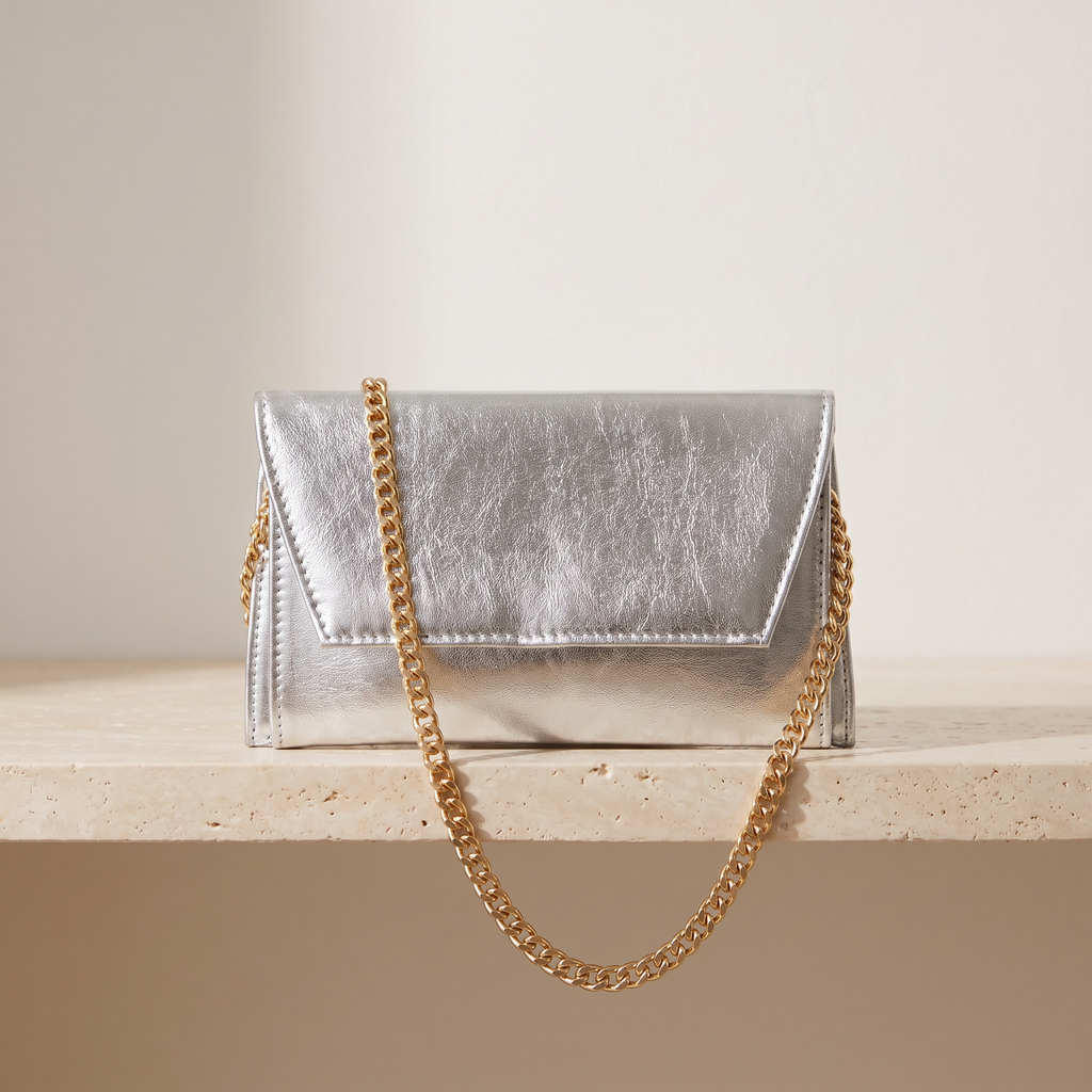 Astra gümüş zarf clutch — travertin zeminde önden görünüm