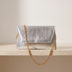 Astra gümüş zarf clutch — travertin zeminde önden görünüm