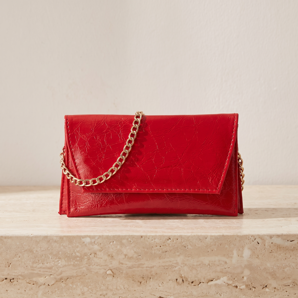 Astra kırmızı zarf clutch — travertin zeminde önden görünüm